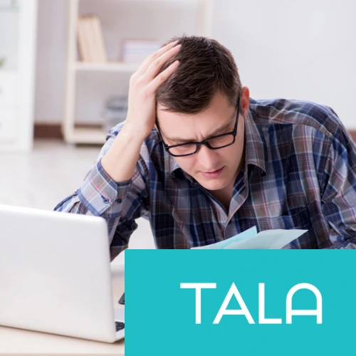 Un hombre con lentes frustrado frente a una laptop